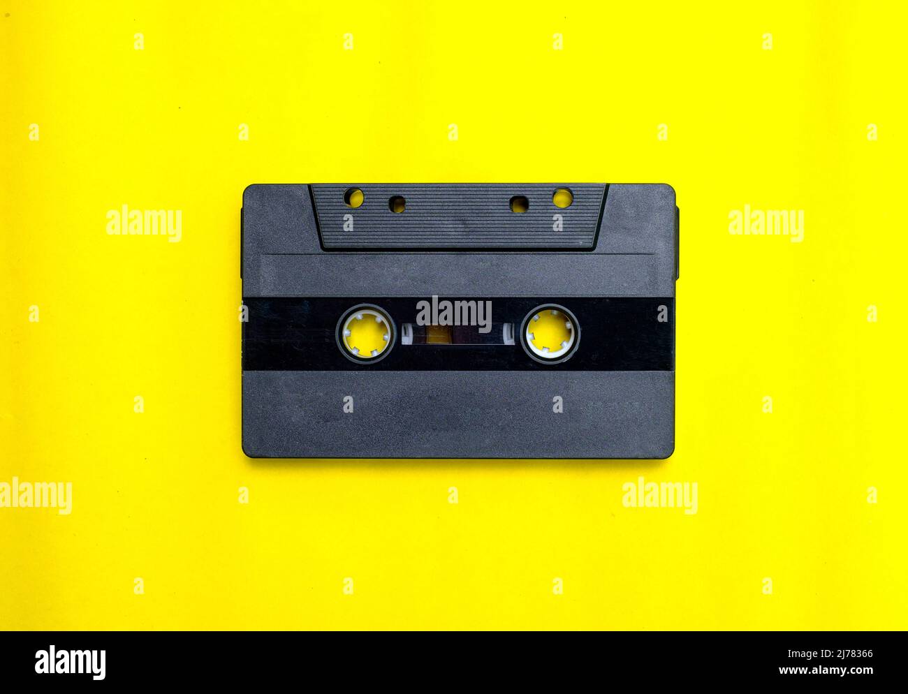 Old compact cassette tape on yellow background Stock Photo