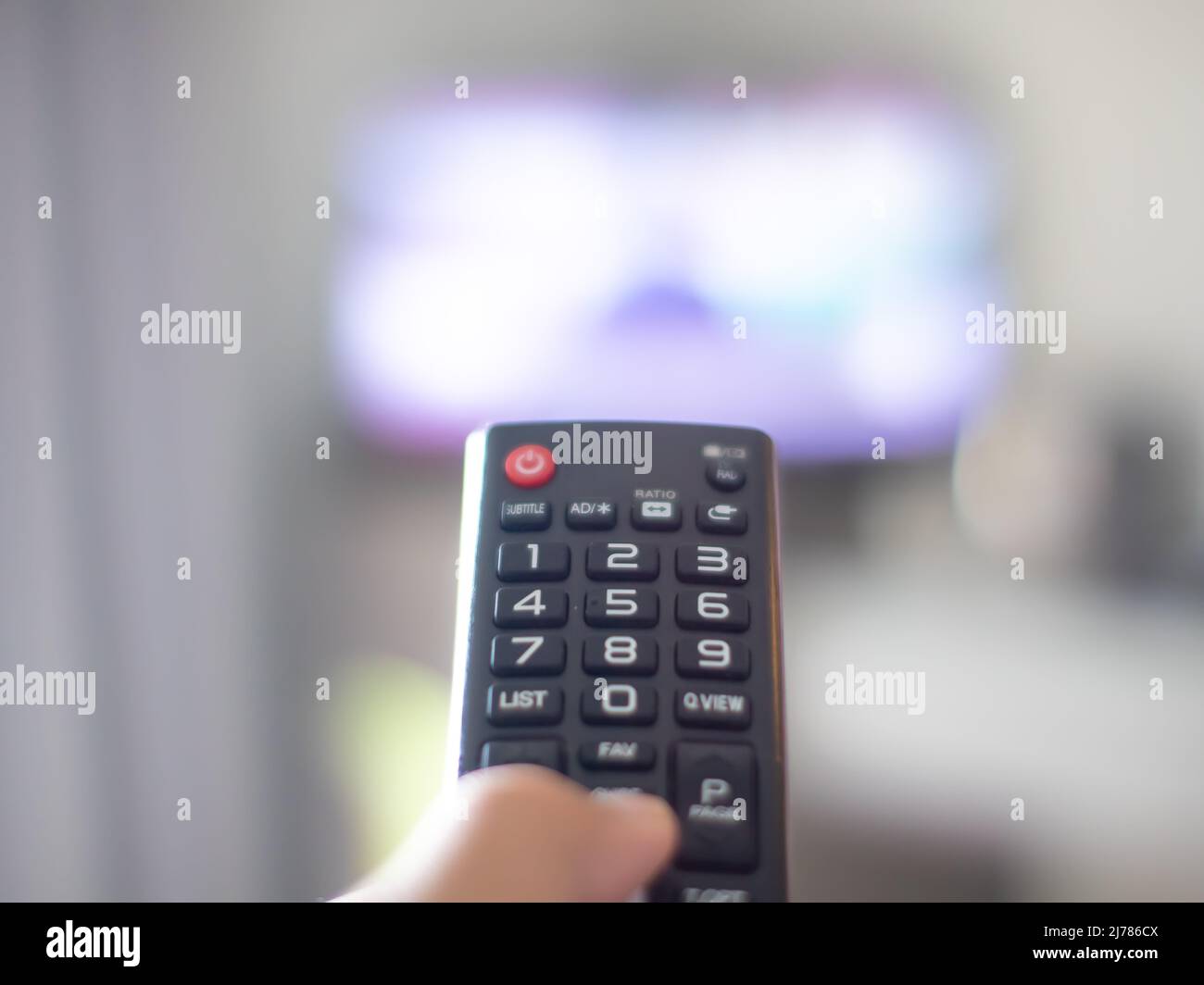 holding the remote to turn on the tv Stock Photo Alamy