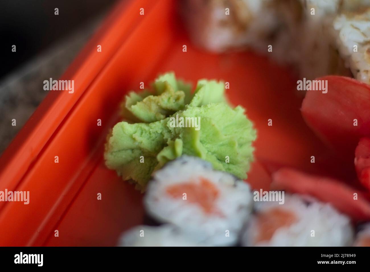Oriental cuisine. Sushi ordered at home. Delicious dinner. Seafood on rack. Rice and algae. Stock Photo