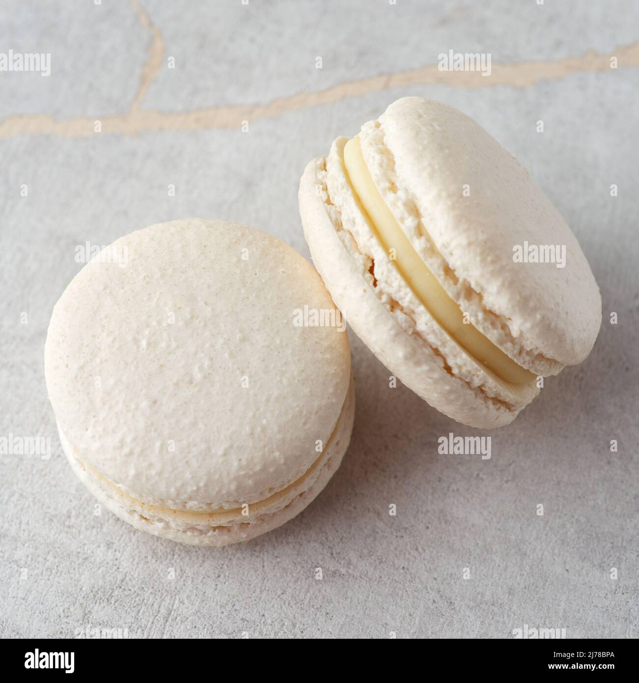 Sweet vanilla macarons on a stone background. Traditional French dessert Stock Photo