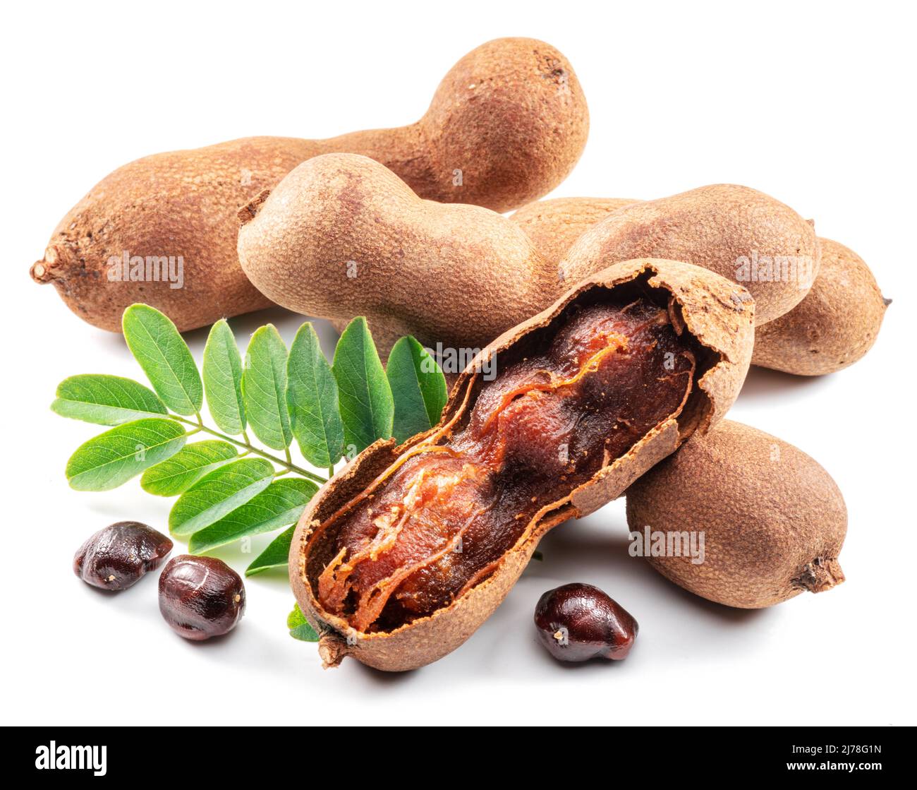 Ripe tamarind fruit, leaves and some tamarind seeds isolated on white