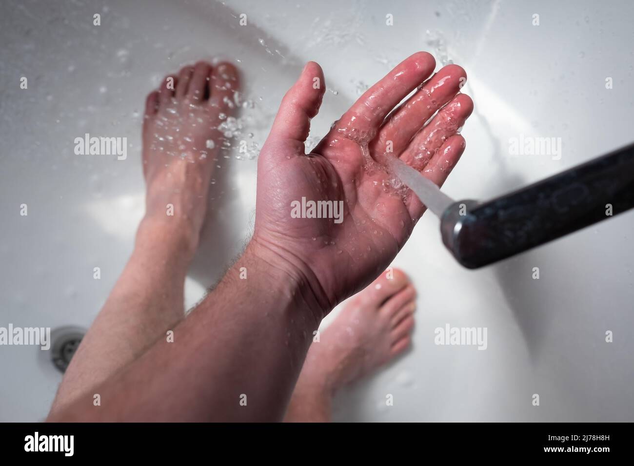 Cold water flows from the faucet. The man does not want to take a