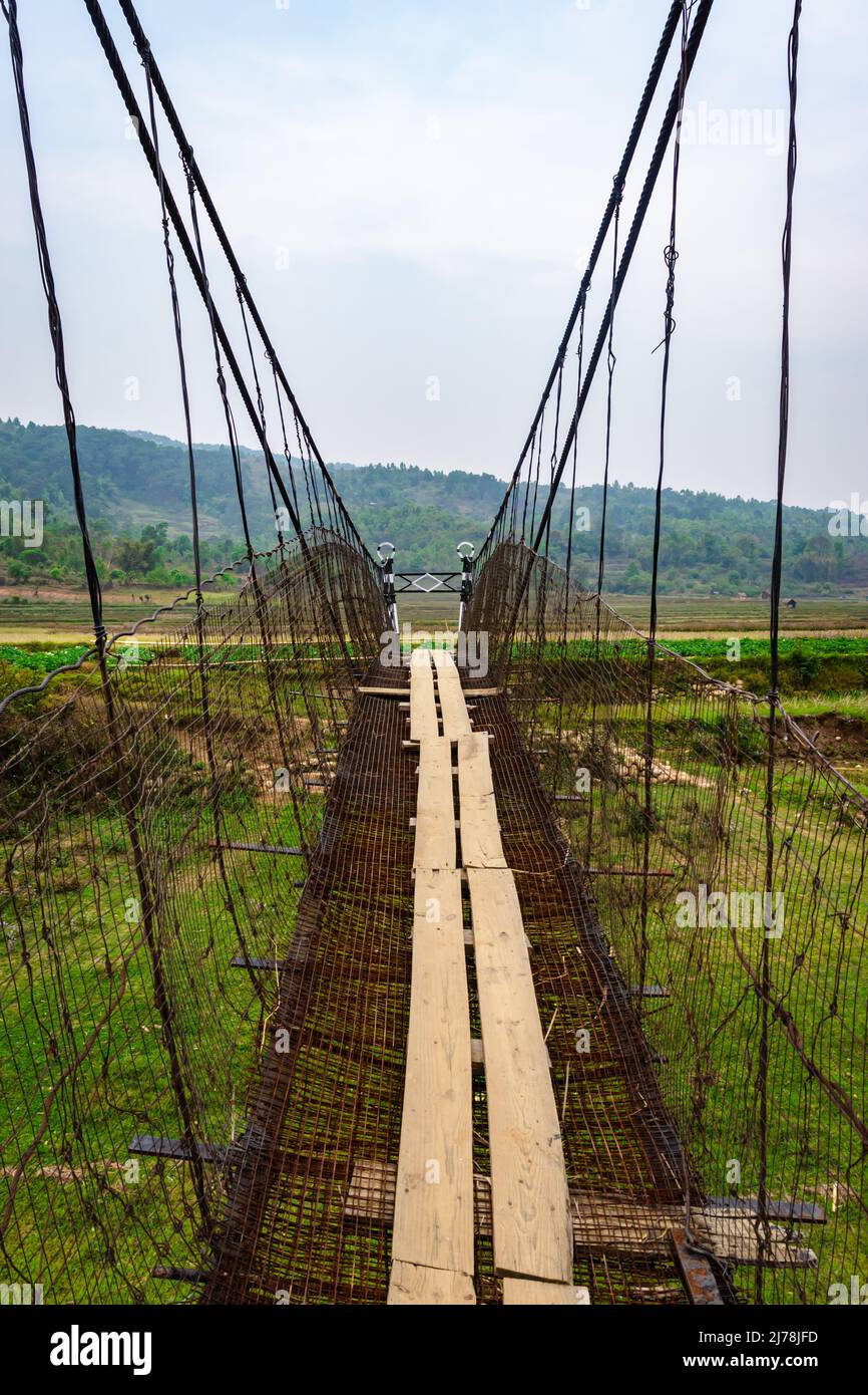 isolated iron suspension bridge old with misty mountain background at morning image is taken at nongjrong meghalaya india. Stock Photo