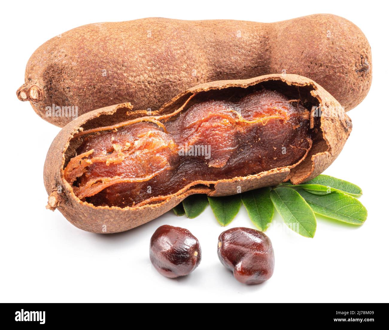 Ripe tamarind fruit, leaves and some tamarind seeds isolated on white