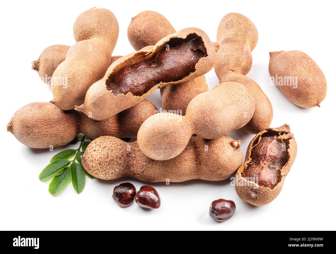 Ripe tamarind fruit, leaves and some tamarind seeds isolated on white