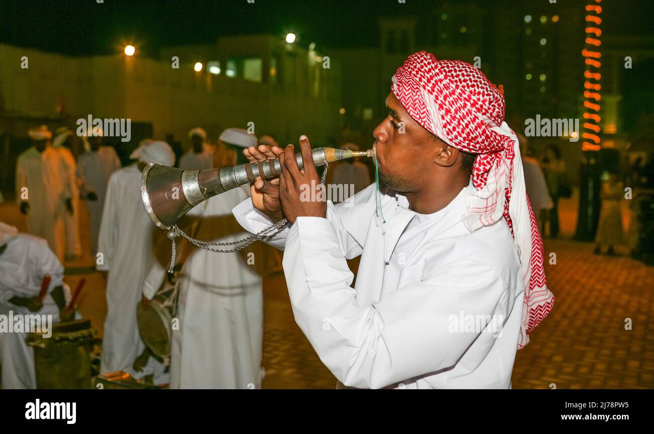 An Arab man playing a mizmar wind instrument during a folk dance at Sharjah's Heritage Days Festival. Stock Photo