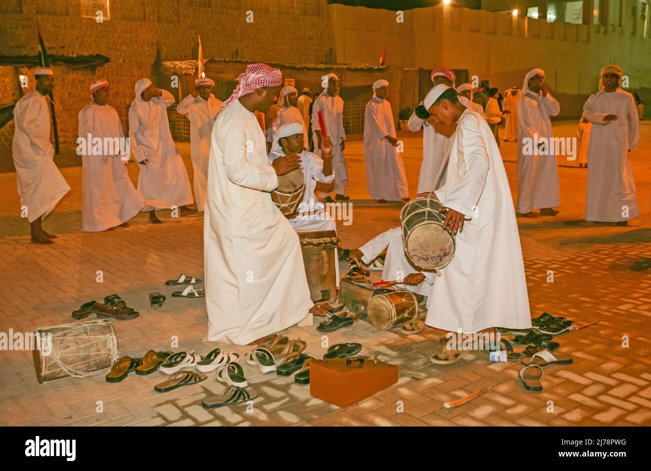 A group of Arab male dancers and musicians performing a folk dance during Sharjah's Heritage Days Festival. Stock Photo