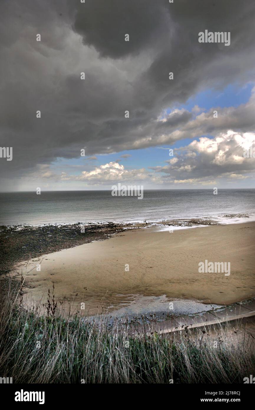 stormy beach with two distant figuresat low tide  west runton north norfolk england Stock Photo