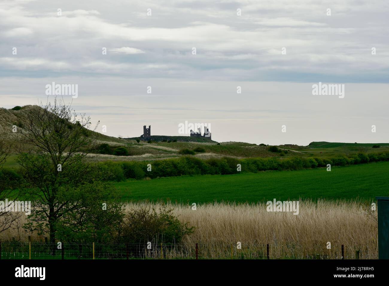 Atmospheric view of Dunstanburgh castle from Embleton bay, Northumberland Stock Photo