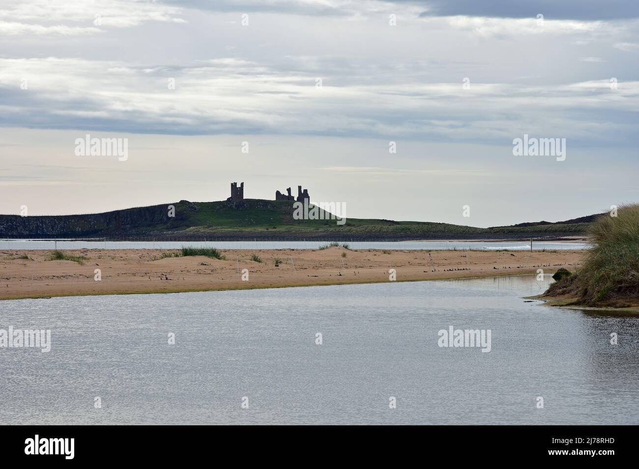 Atmospheric view of Dunstanburgh castle from Embleton bay, Northumberland Stock Photo