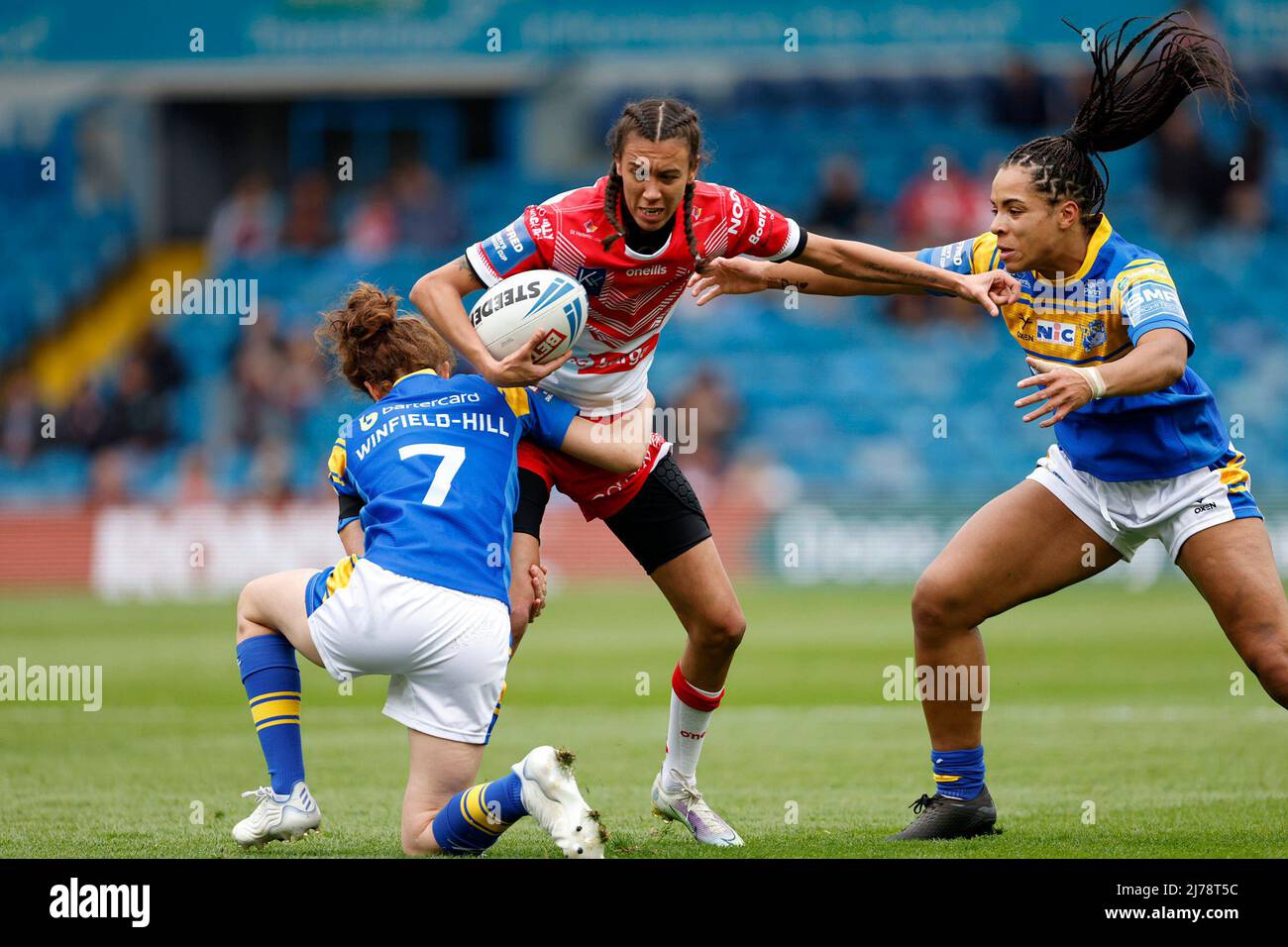 St Helens Zoe Harris is tackled by Leeds Rhinos Courtney Winfield-Hill and Elychia Watson during the Betfred Women's Challenge Cup Final at Elland Road, Leeds. Picture date: Saturday May 7, 2022. Stock Photo