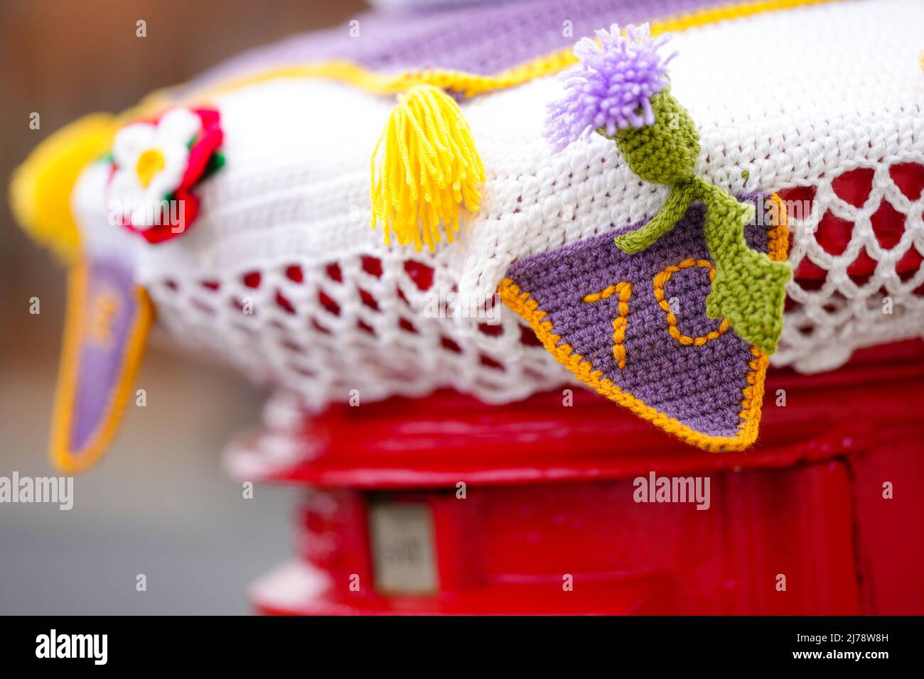 A knitted Platinum Jubilee themed postbox topper in Isleworth, London. Picture date: Saturday May 7, 2022. Stock Photo