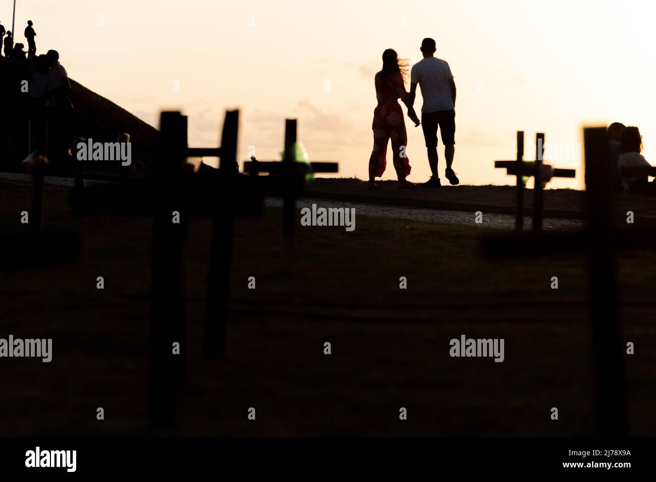 Salvador, Bahia, Brazil - October 01, 2021: Silhouette of people and crosses fixed on the ground in honor of those killed by covid-19. Sunset in Salva Stock Photo