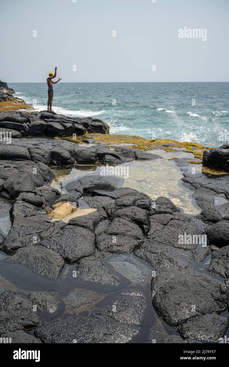 Man fishing by hand on the cliffs near the tourist site known as Boca do Inferno. Stock Photo