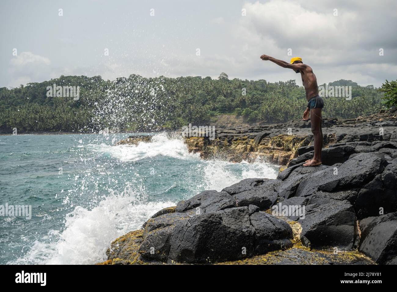 Man fishing by hand on the cliffs near the tourist site known as Boca do Inferno. Stock Photo