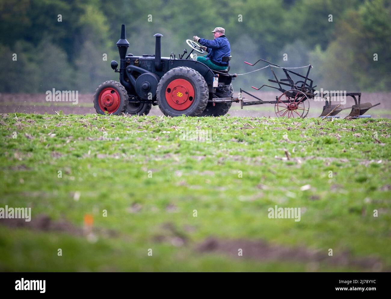 West Mecklenburg, Germany. 7th May 2022. 07 May 2022, Mecklenburg-Western Pomerania, Brüsewitz: Ulf Zinck drives his 1941 Lanz Bulldog across the field during the 19th West Mecklenburg Plowing Competition. The best plowers from the districts of Parchim, Ludwigslust and Northwest Mecklenburg compete with state-of-the-art technology in the two disciplines of bed plowing and reversible plowing. Another highlight is the show plowing with historical agricultural technology. Photo: Jens Büttner/dpa Credit: dpa picture alliance/Alamy Live News Stock Photo