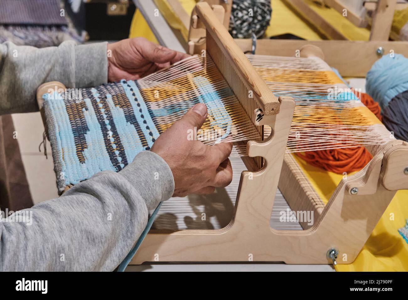 Hands of senior man weaving small rug with pattern on manual table loom  Stock Photo - Alamy