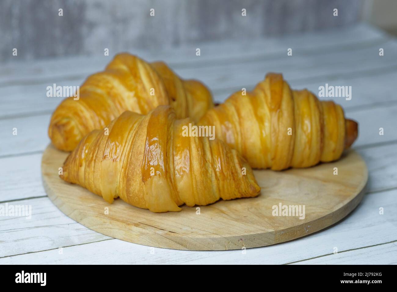 Some fresh croissants on a wooden surface Stock Photo