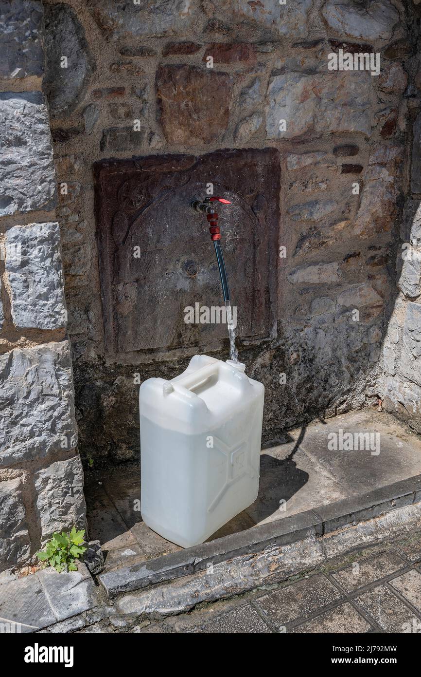 Filling water into a canister, in Karies, Chios island, Greece Stock Photo