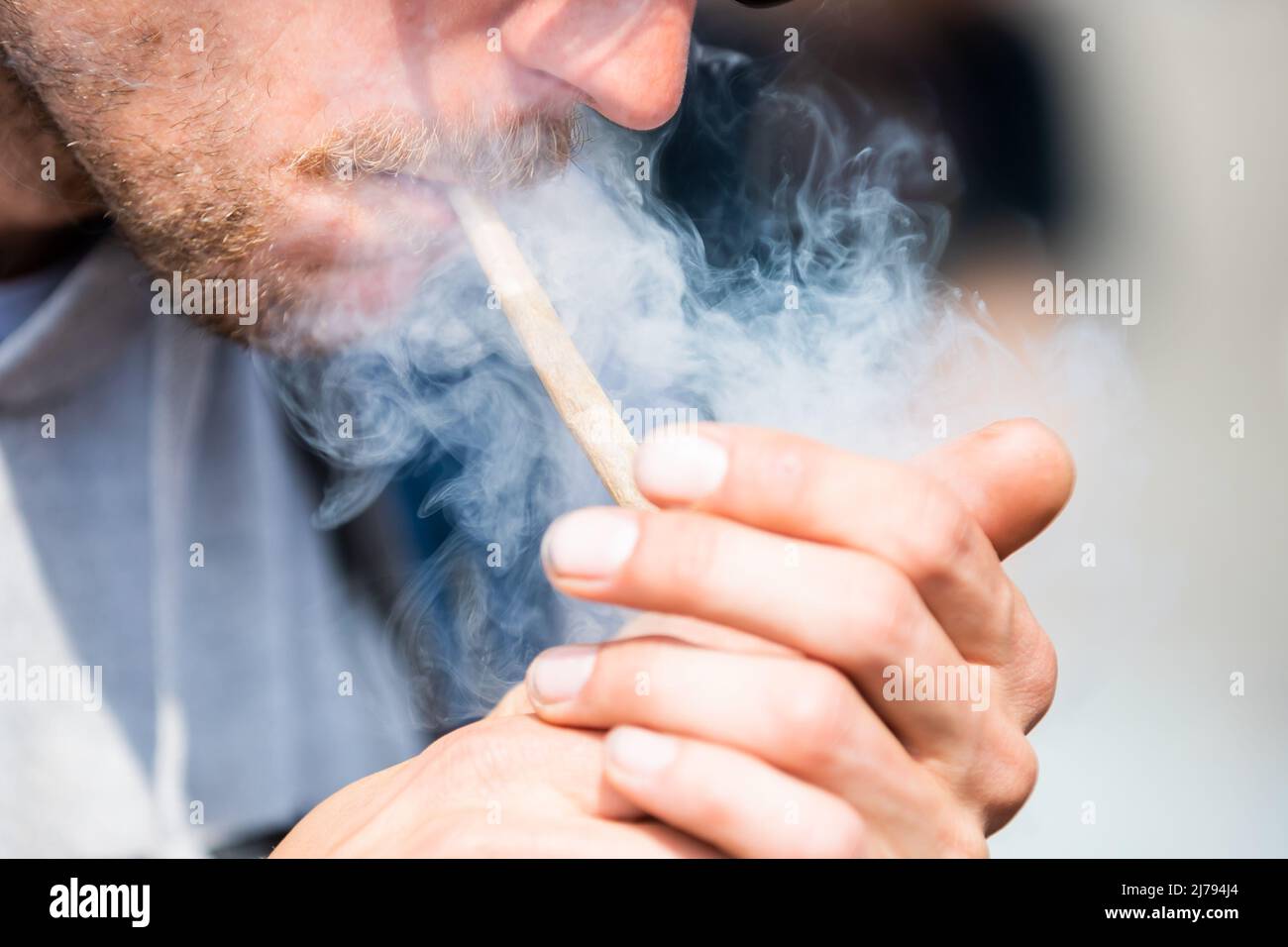 07 May 2022, Berlin: A man smokes a joint of medical cannabis at the Brandenburg Gate during the kick-off rally of a demonstration for the swift legalization of cannabis, the Global Marijuana March 2022. Photo: Christoph Soeder/dpa Stock Photo