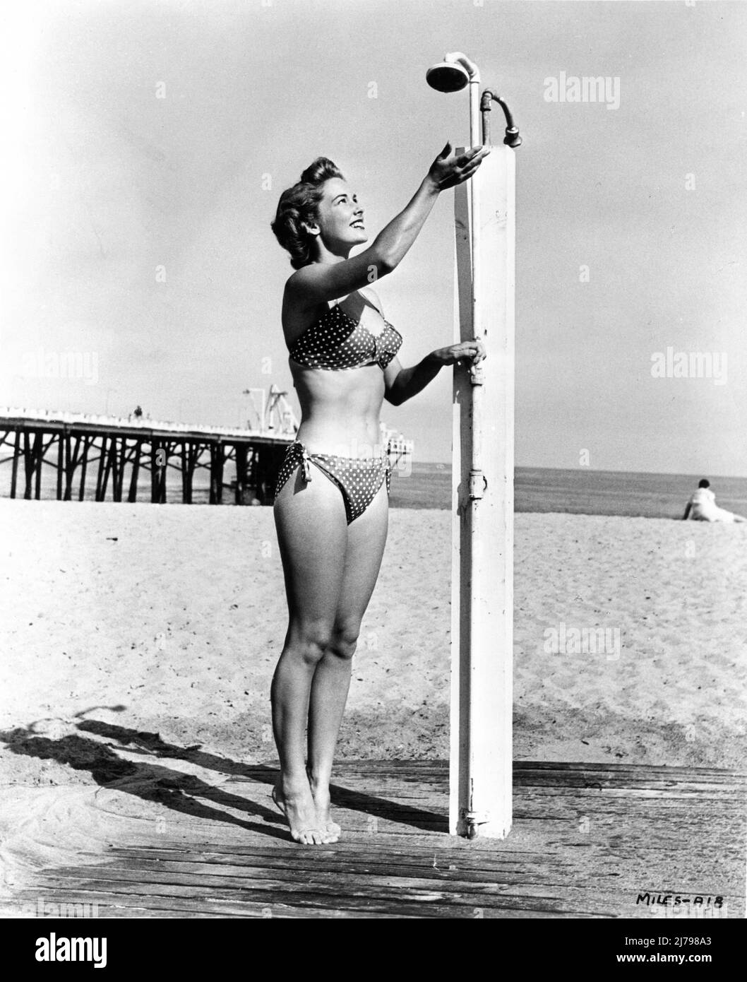 VERA MILES  circa 1956 poses in bikini having a shower on California beach publicity for Warner Bros. Stock Photo