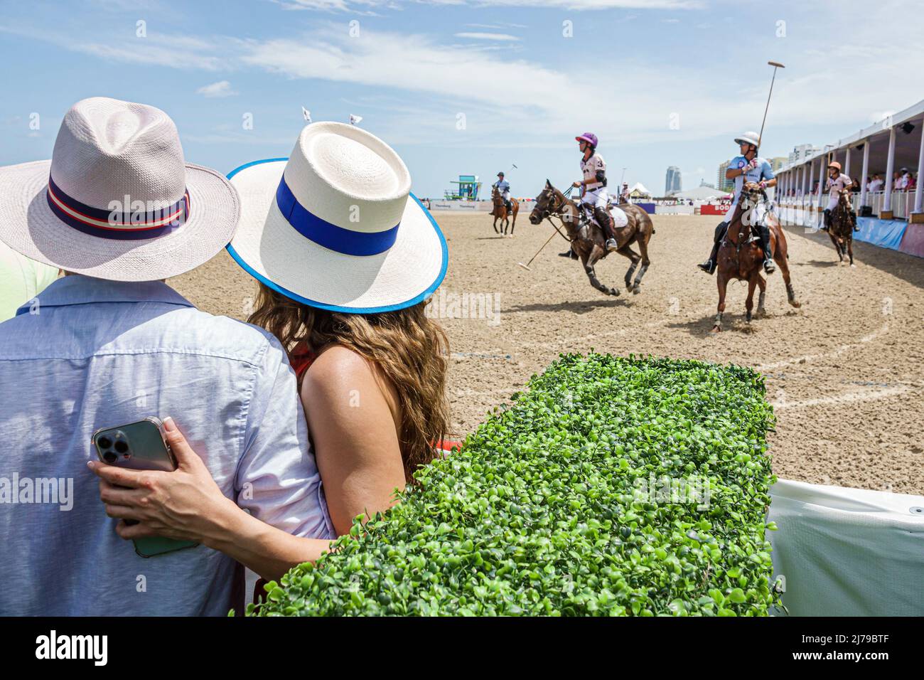 Miami Beach Florida Beach Polo World Cup Miami annual event game chukker ponies horses players player mallets mallet ball couple watching man woman we Stock Photo