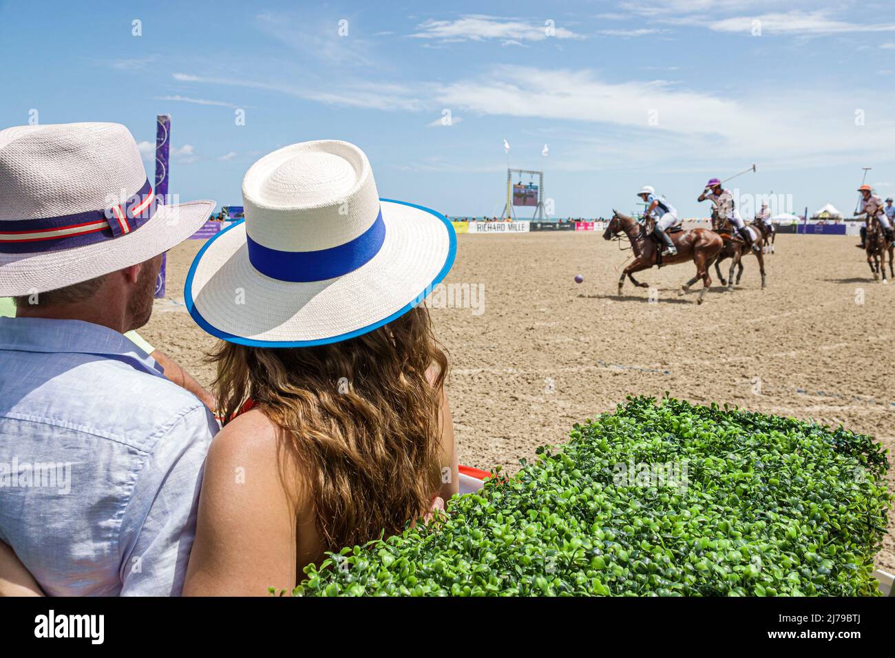 Miami Beach Florida Beach Polo World Cup Miami annual event game chukker ponies horses players player mallets mallet ball couple watching man woman we Stock Photo