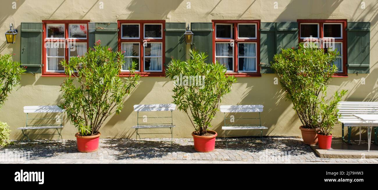 Facade of an old building with plant and chairs at the old town of Dinkelsbühl Stock Photo