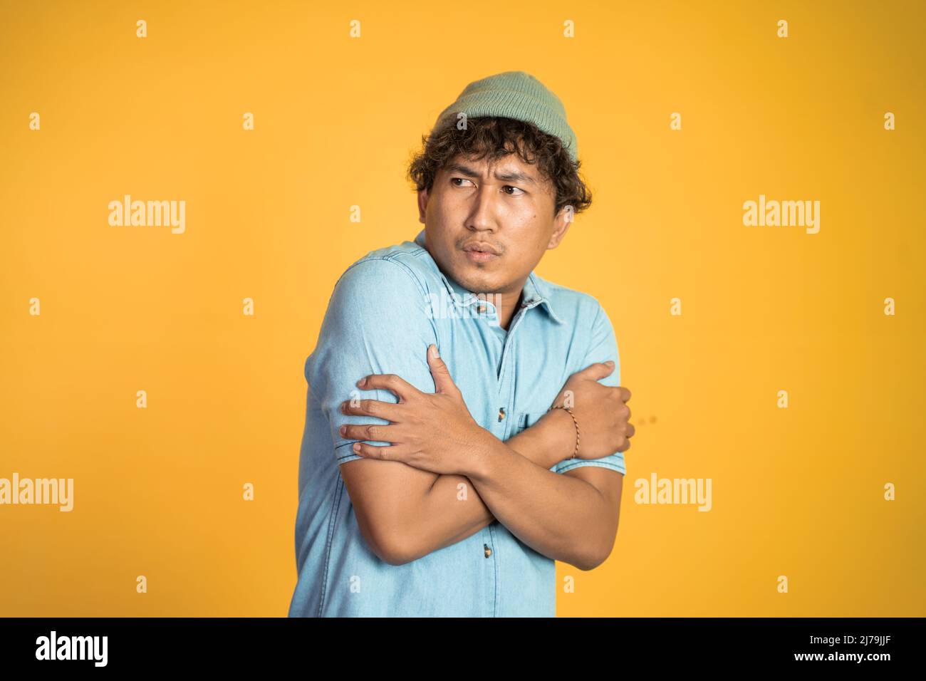 man shivering while holding his two arms hug himself Stock Photo