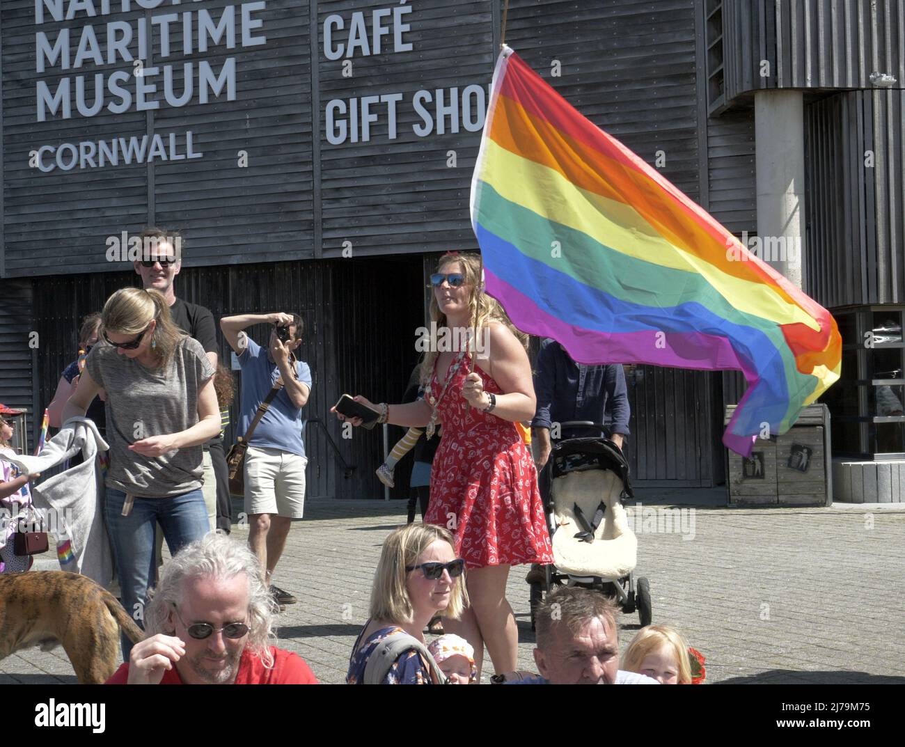 Falmouth Cornwall, UK 07th May 2022. A hero deputy town mayor replete with the chain of office and clutching her Rainbow pride flag is seen running towards a fire which has broken out in steak restaurant located in the Event square of Falmouth town. The Big Gay pride entertainment venue had to be evacuated for the safety of the crowds attending. Councillor Kirsty Edwards is a keen supporter of minority rights.  Falmouth Cornwall   Robert Taylor Alamy Live News Stock Photo