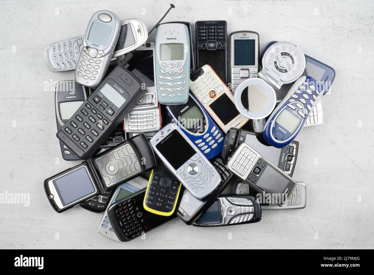 Prague, CZ- 12 December 2021:  Heap of Various brands and generations of old mobile phones gadgets. Editorial Stock Photo