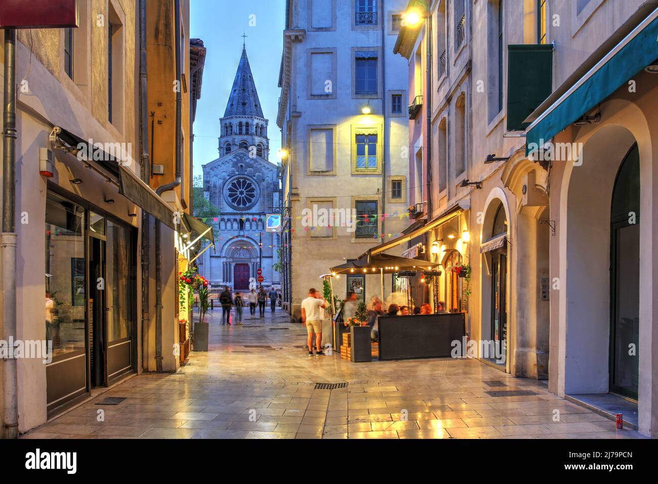 Street scene along the Rue de la Madelaine in old town of Nîmes, France with St. Paul Church in the background. Stock Photo