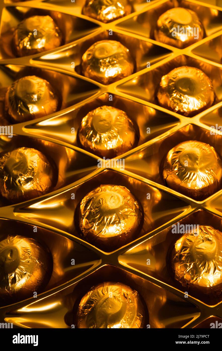 Box of gold foil wrapped chocolates Stock Photo