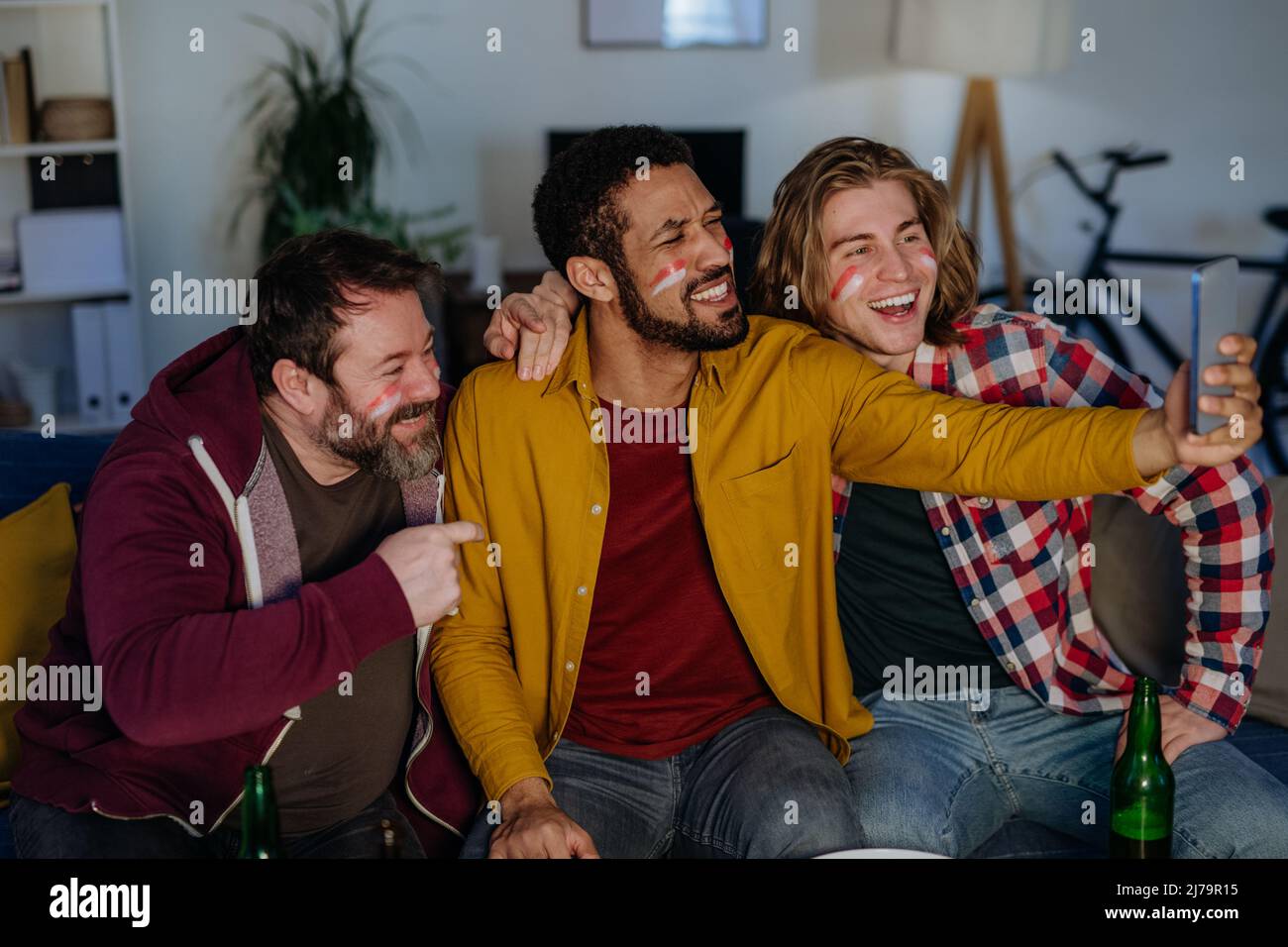 Happy football fans friends watching football at home and taking selfie Stock Photo