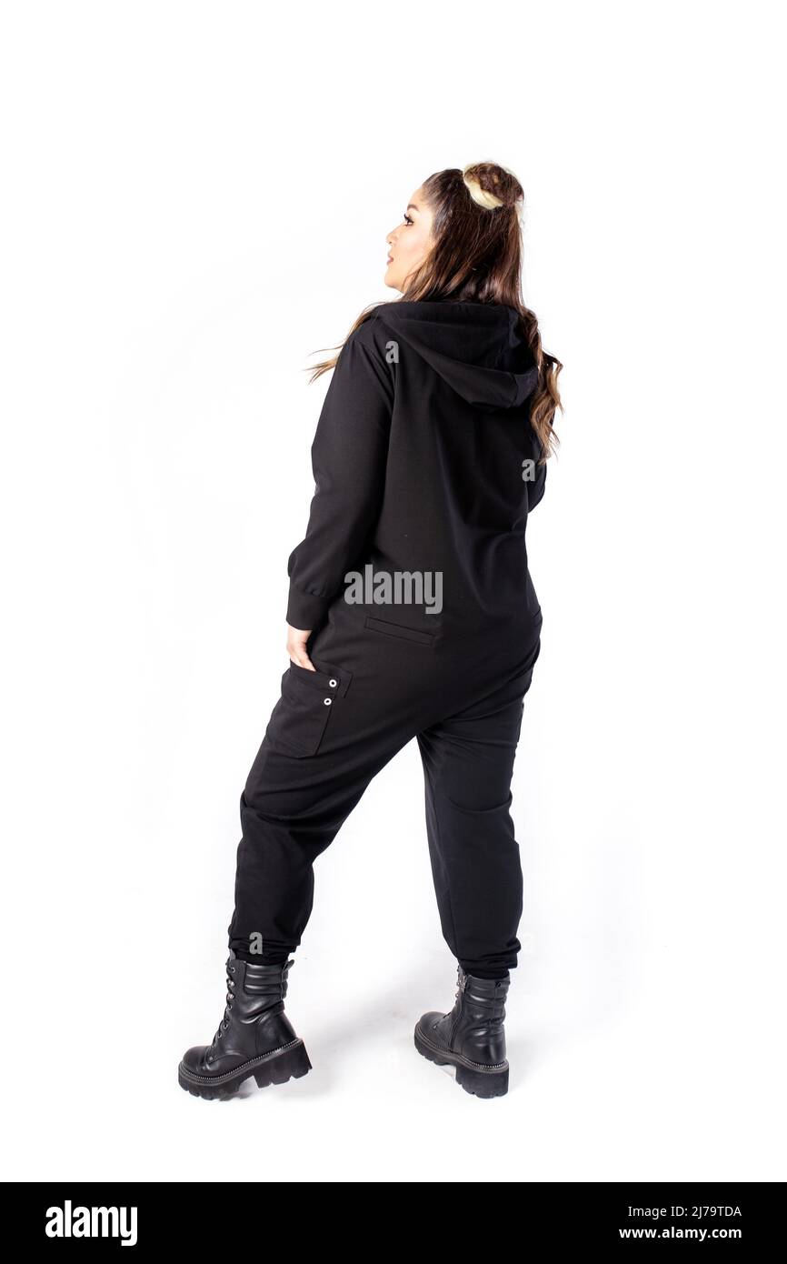 girl stands with her back on a white background in black clothes. Stock Photo