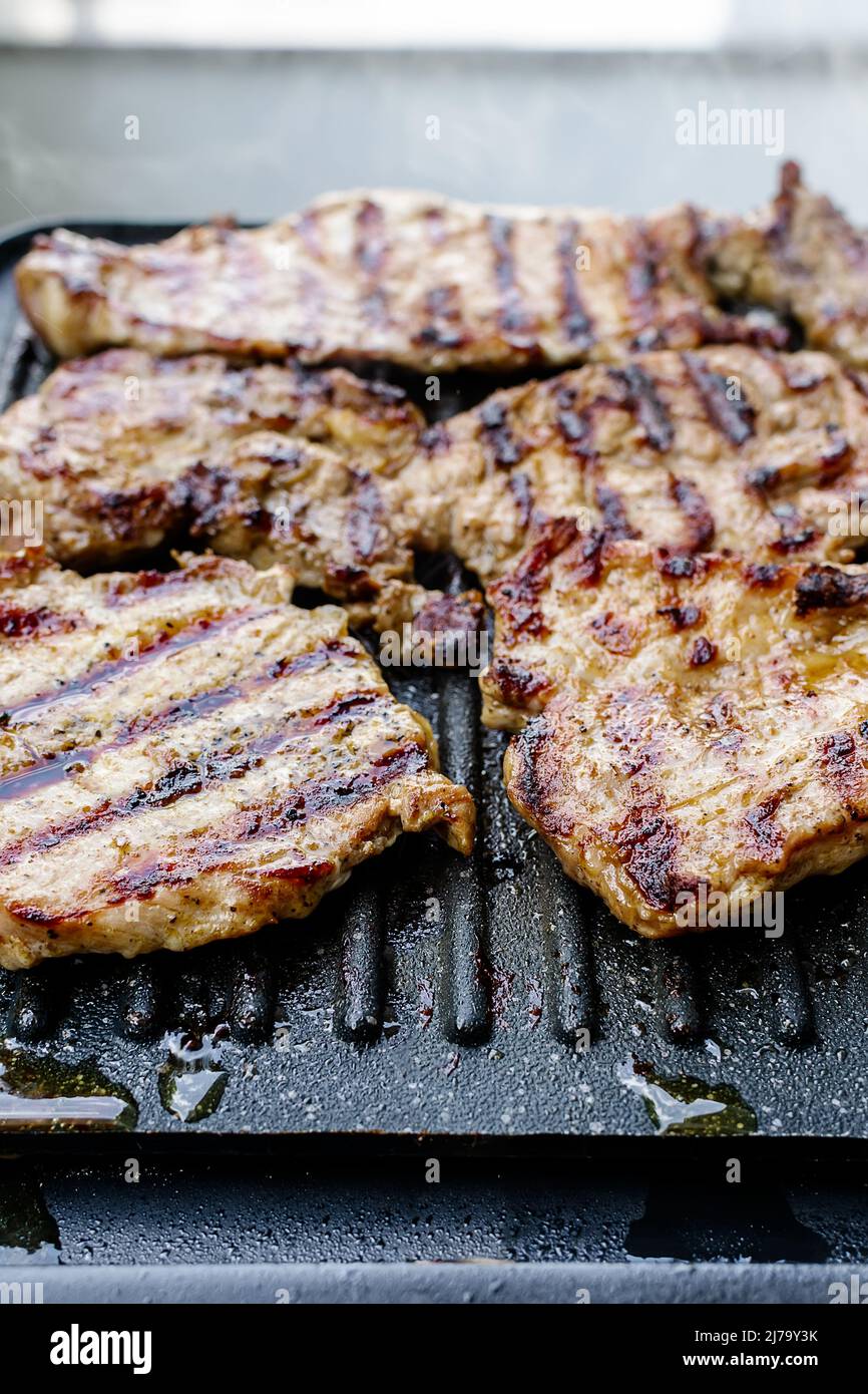 Juicy pork neck steaks on teflon barbecue grill Stock Photo Alamy