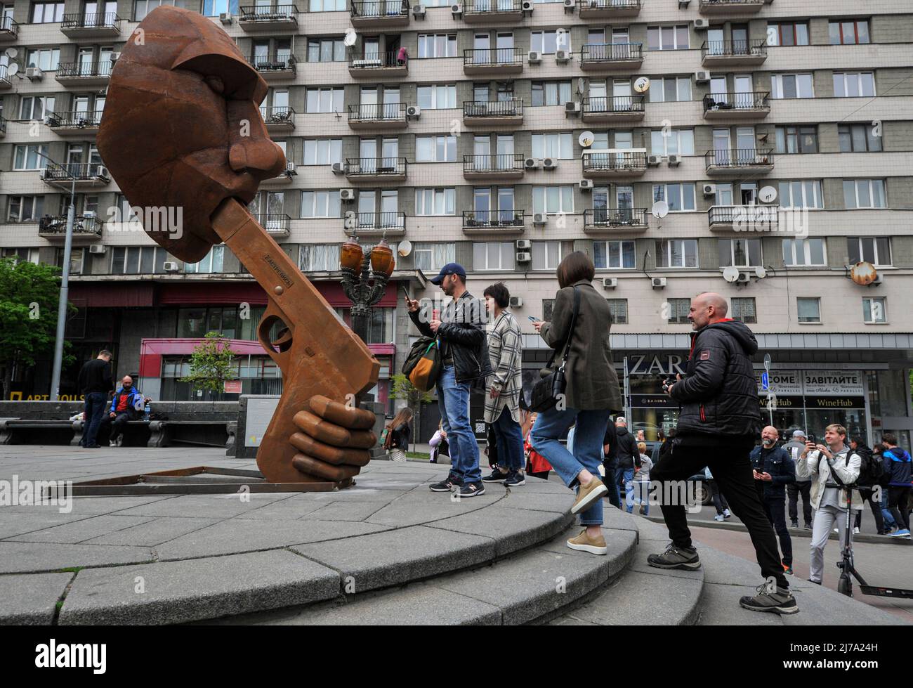 People take pictures of a sculpture depicting the President of Russia