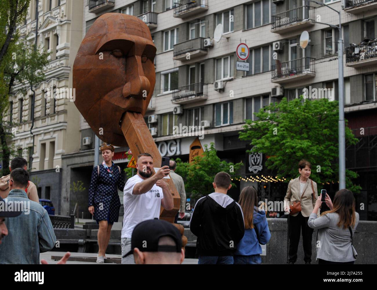 People take pictures next to the sculpture depicting the President of