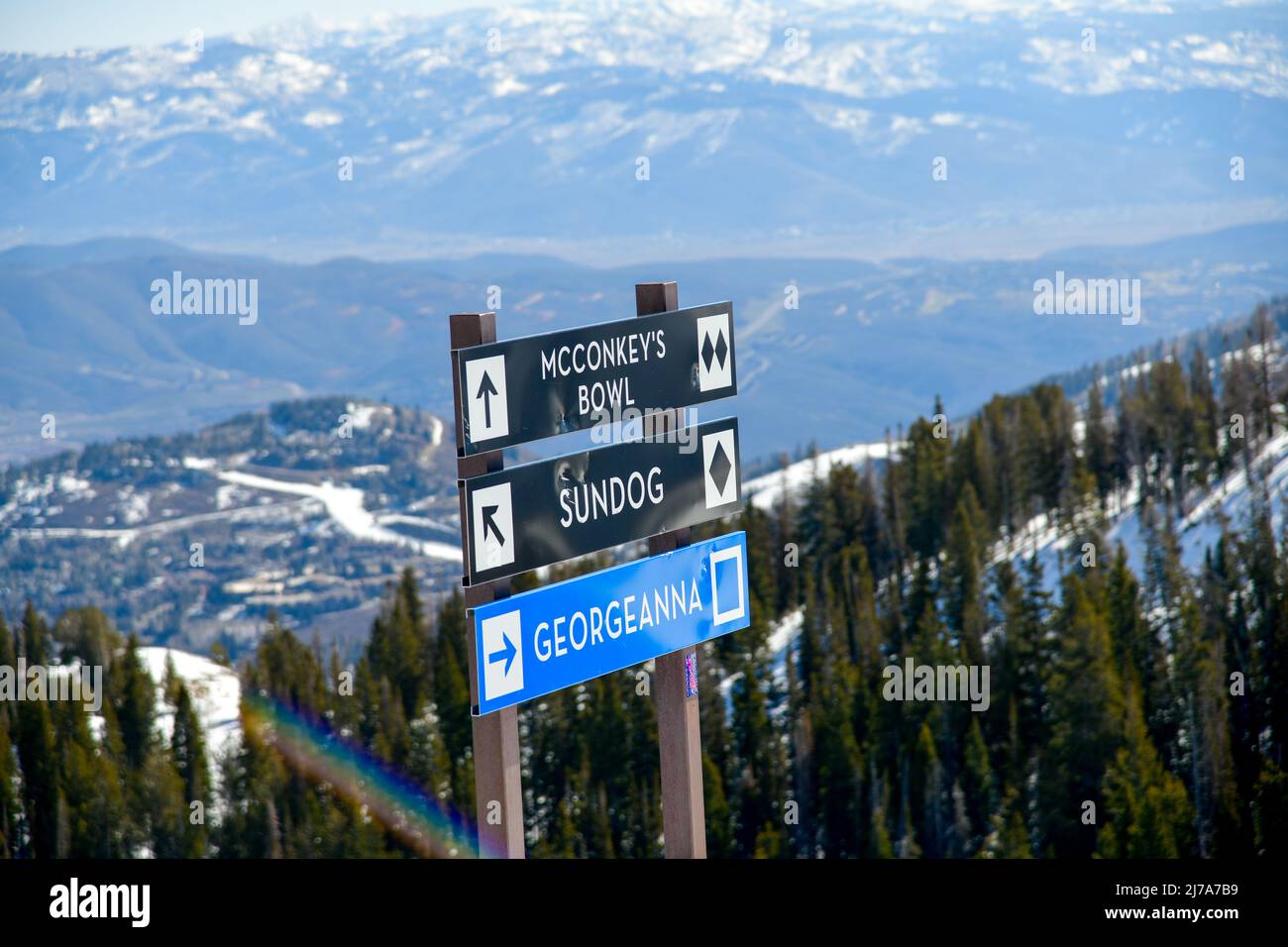 Trail sign at Park City Ski Area, Utah. Top view to the valley with mountains range during early spring weather conditions. Stock Photo