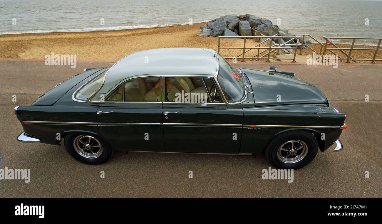 Classic  Blue and White Rover 3.5Litre Car parked on seafront promenade with beach and sea in background. Stock Photo