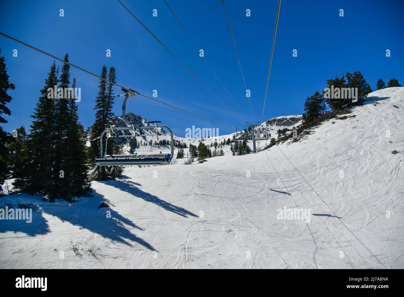 Chair lift going up at the Snowbasin Ski Resort in Utah. Ski vacation in early spring season. Stock Photo