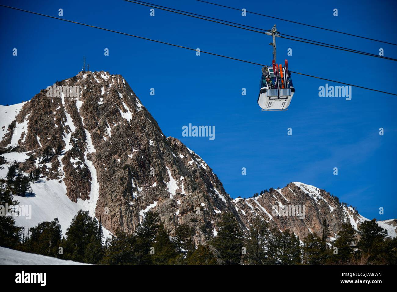 Gondola lift going up at the Snowbasin Ski Resort in Utah. Beautiful landscape of rocky mountains around. Stock Photo
