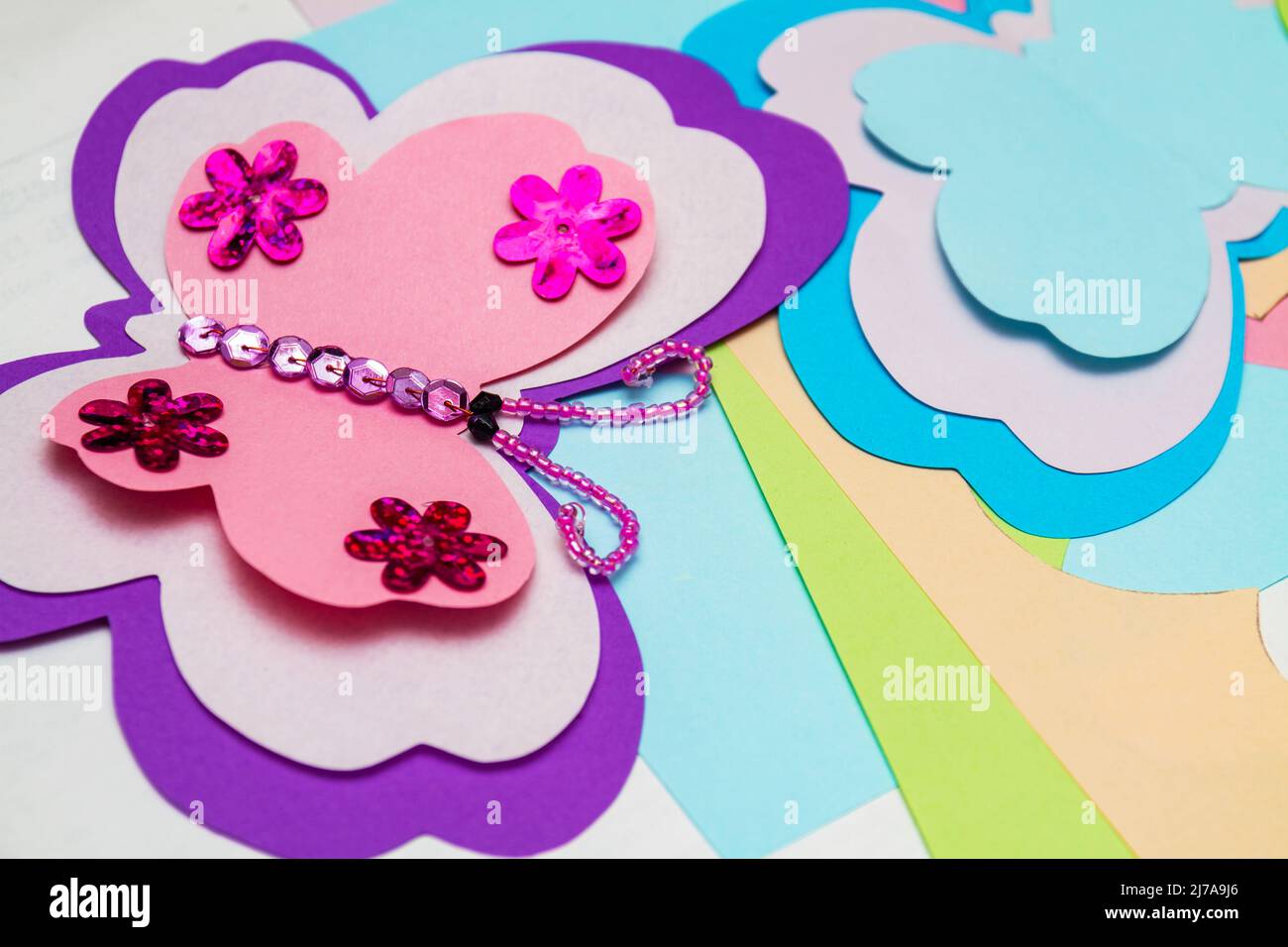 Application made with hot melt glue gun. Butterfly made of colored paper,  multi-colored sequins, paillettes and beads. Closeup, selective focus Stock  Photo - Alamy