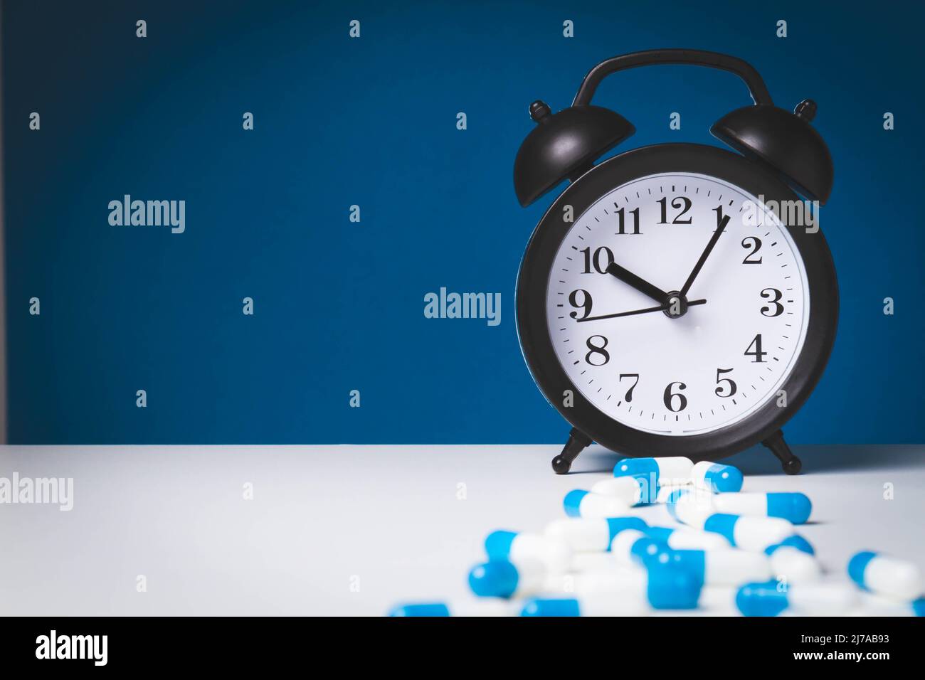 Time to take your medicine. Pill reminder. Tablets and alarm clock.  Notification of the doctor about the prevention of the disease Stock Photo  - Alamy