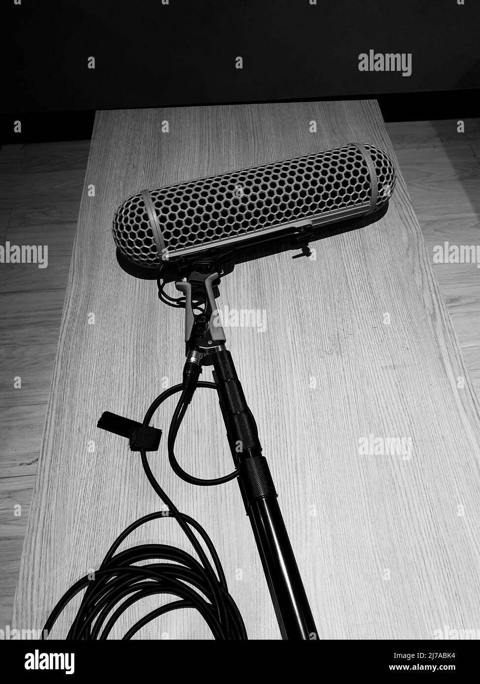 Boom Microphone or ambient mic for sound recording in video production. Boom microphones lay down on wood table after using in filming online movie. P Stock Photo