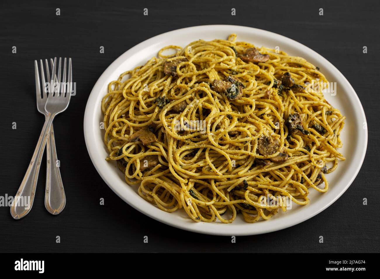 Homemade Spinach Mushroom Pesto Spaghetti on a Plate on a black