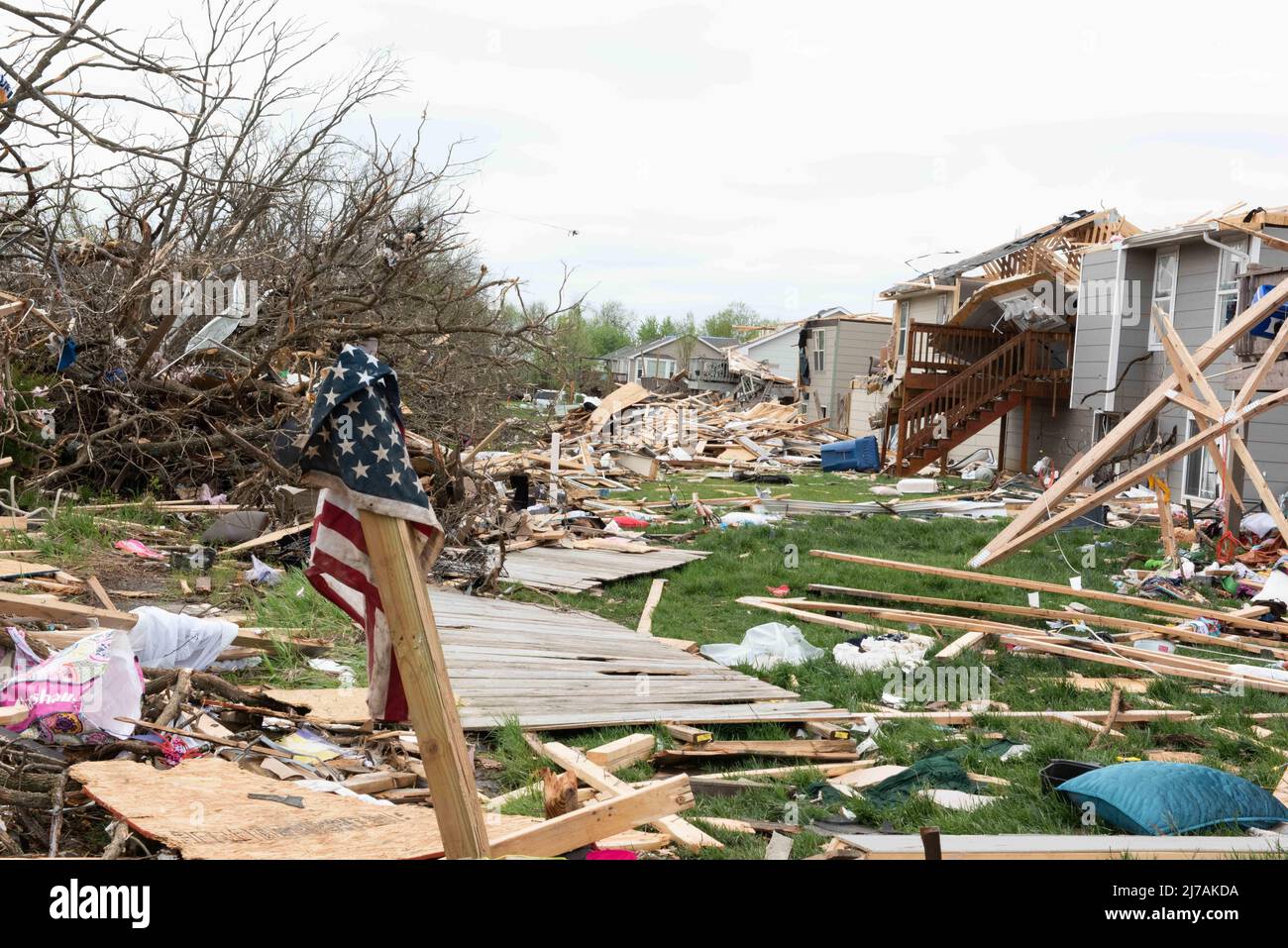Andover, United States of America. 29 April, 2022. A tattered American Flag hangs on a pole outside damaged homes in the aftermath of an EF-3 tornado, April 29, 2022, in Andover, Kansas. The tornado damaged hundreds of buildings in the Wichita suburb.  Credit: A1C Felicia Przydzial/U.S. Air Force Photo/Alamy Live News Stock Photo