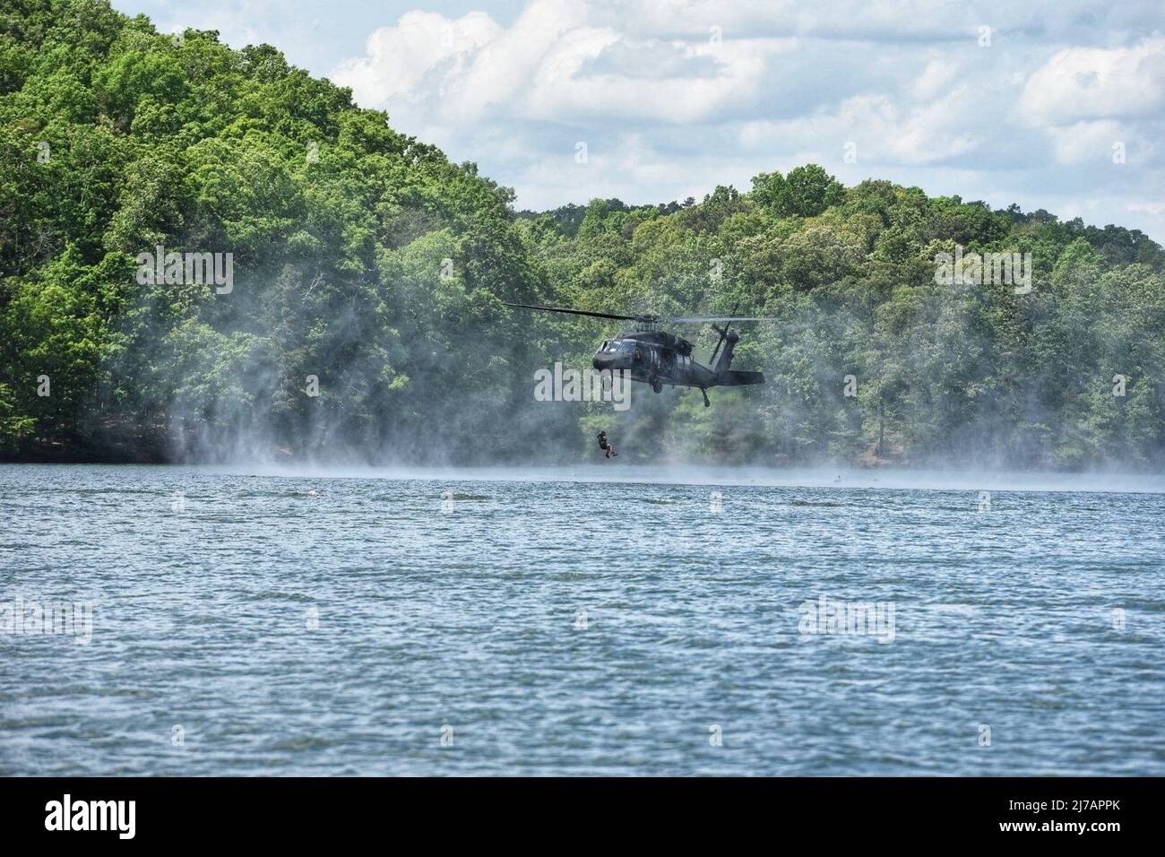 A Soldier from the 5th Ranger Training Battalion jumps from a UH-60 Black Hawk helicopter into Lake Lanier, Georgia, May 3, 2022. Helocasting is an insertion technique developed by Airborne troops whereby Soldiers step off the aircraft's ramp at a low altitude and low speed directly into the water below. (U.S. Army photo by Christopher Carranza) Stock Photo