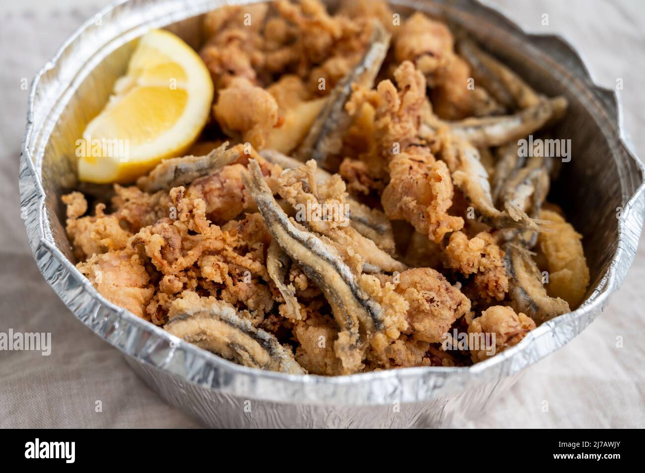 Spanish sea food, cripsy deep fried baby octopus, fish, calamari rings served with lemon, close