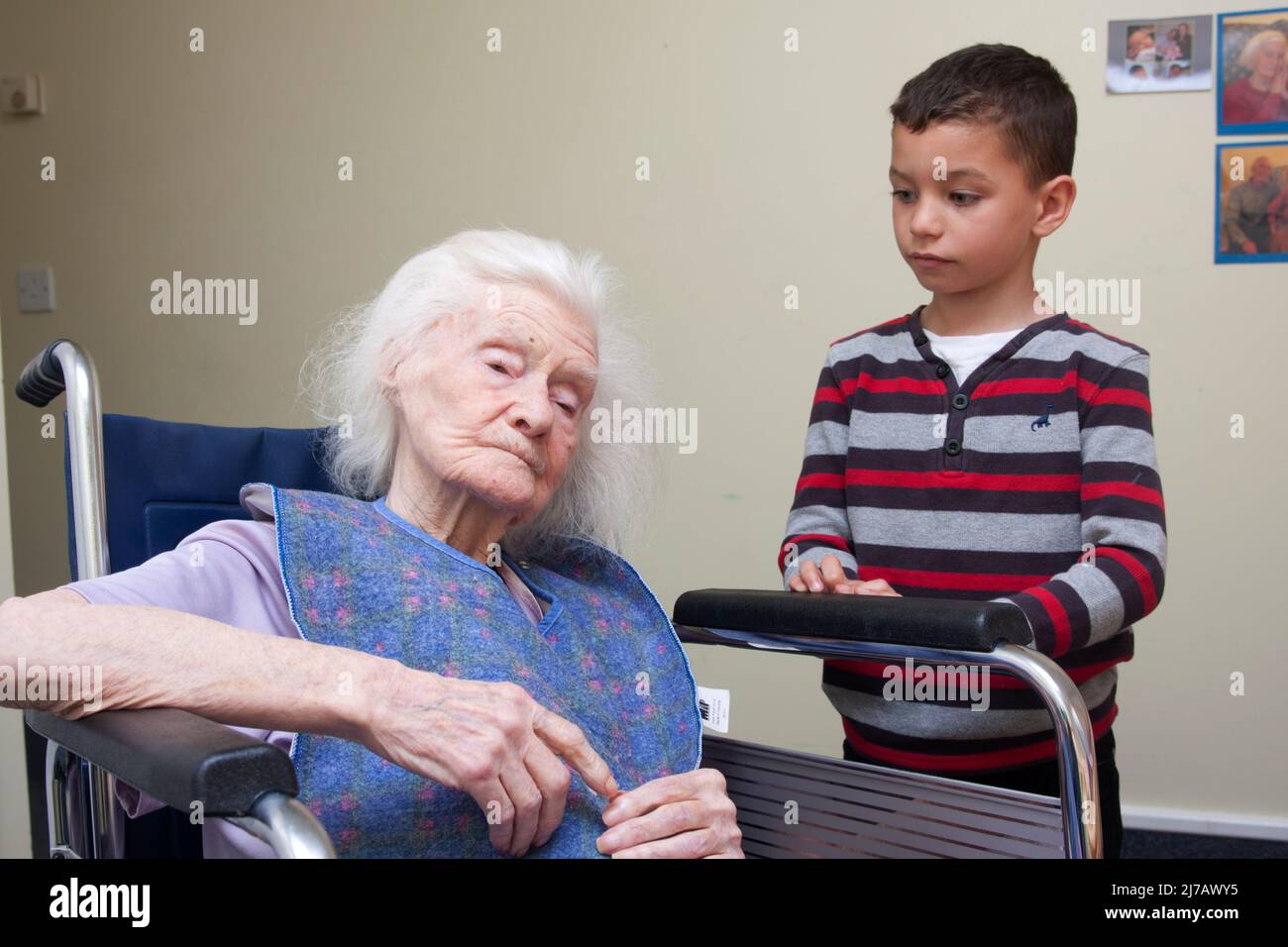 young boy visiting his very old great grandmother in care home Stock Photo